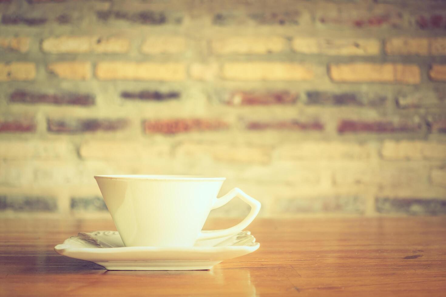A white cup and saucer on a wooden table photo