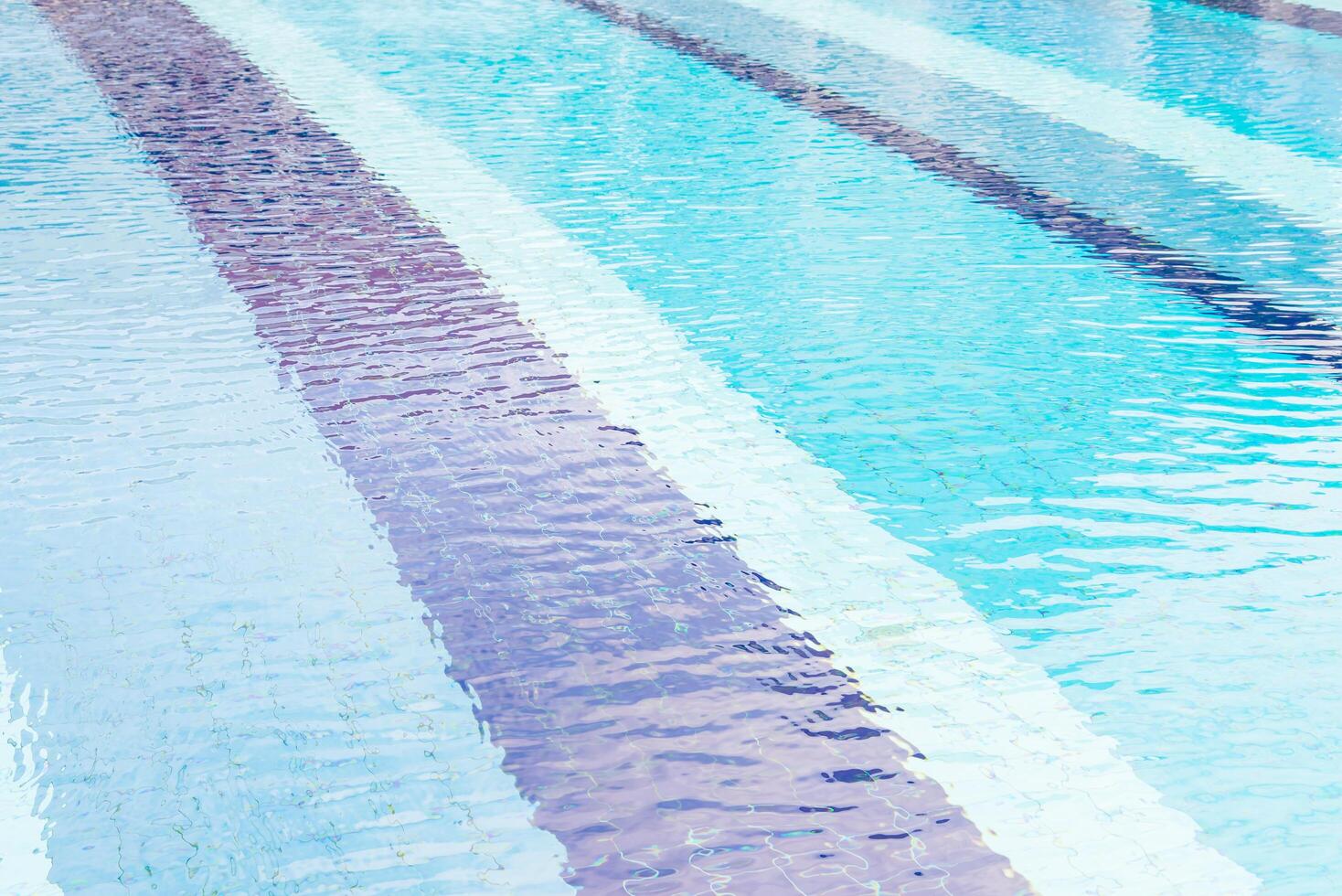 A man in a blue suit is standing in a pool photo