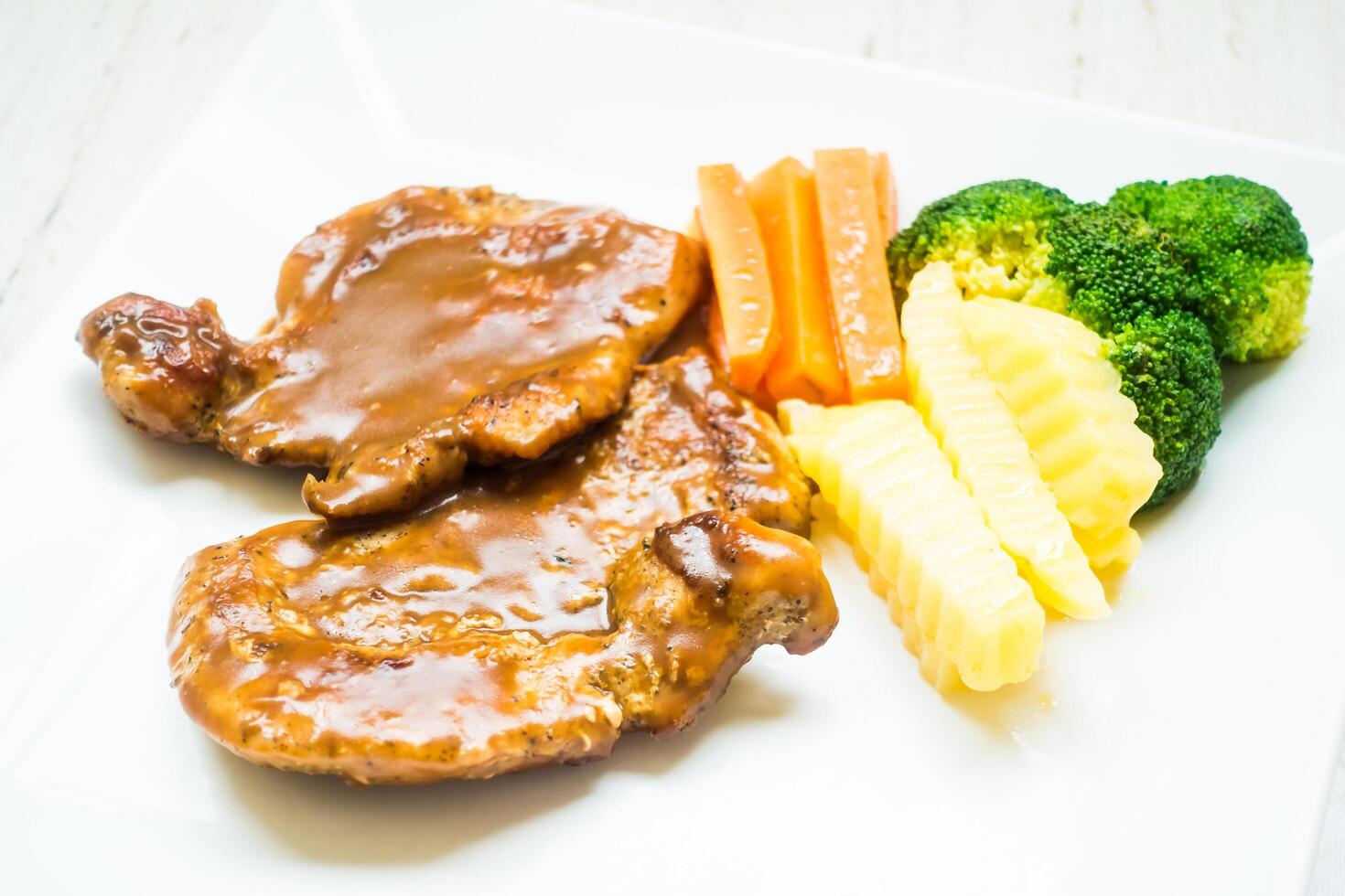 A plate with meat, vegetables and sauce photo