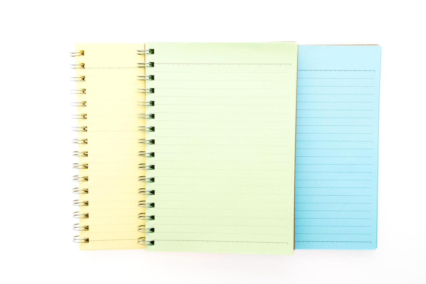 Three notebooks with different colors on a white background photo
