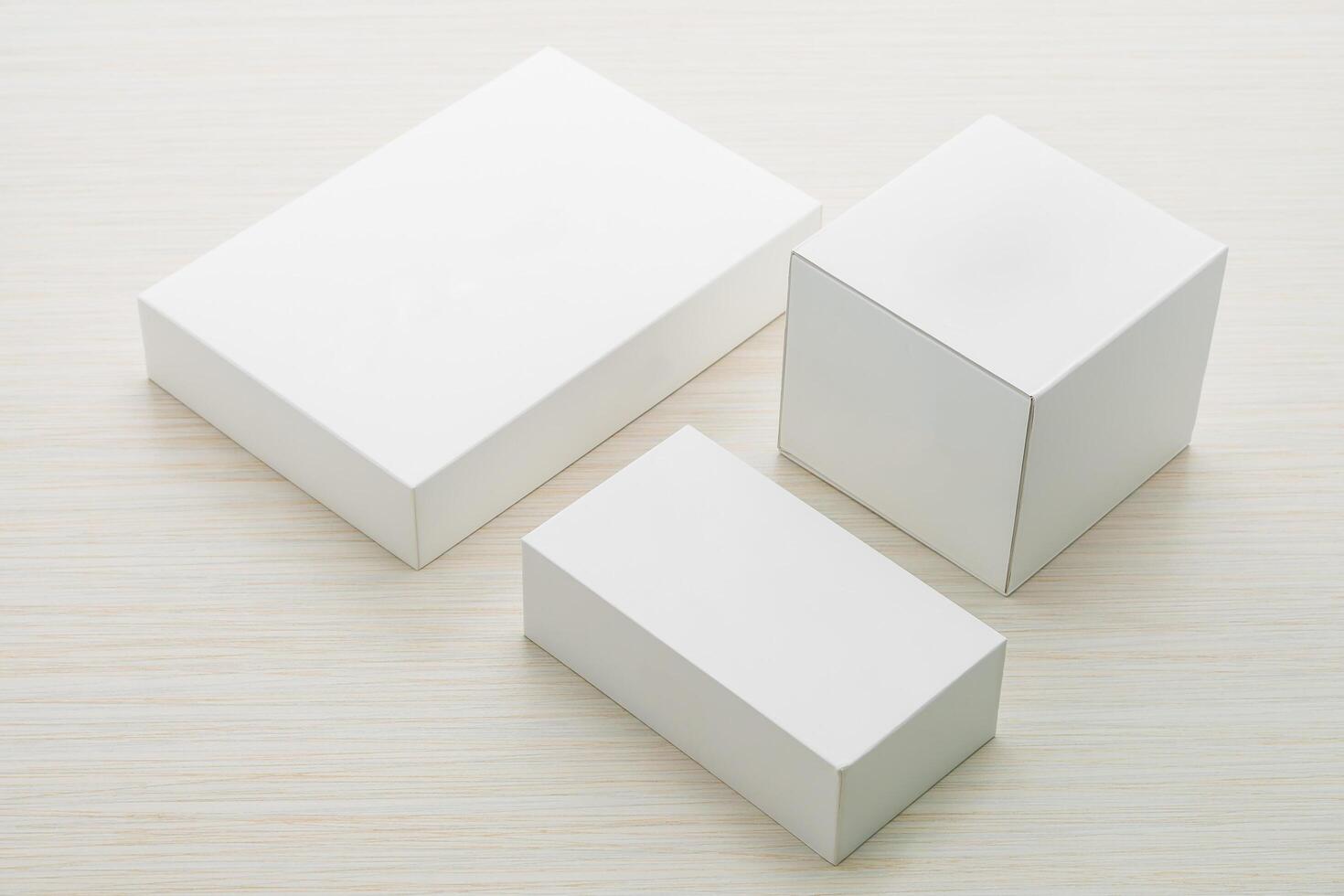 Three white boxes on a wooden surface photo