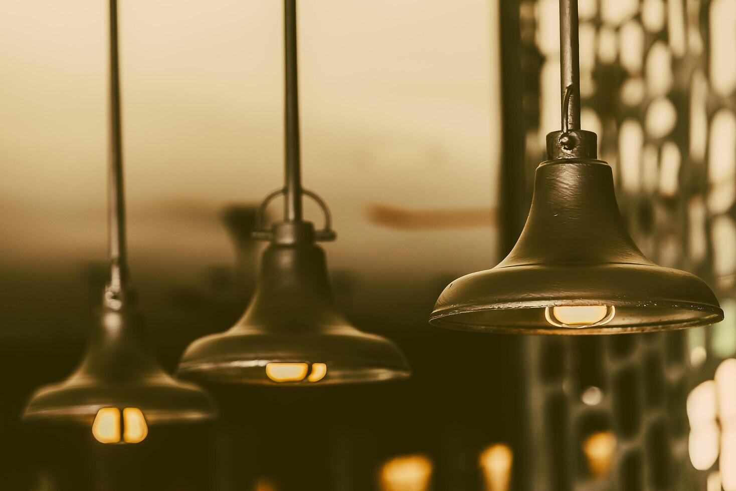 Three light bulbs hanging from a ceiling photo