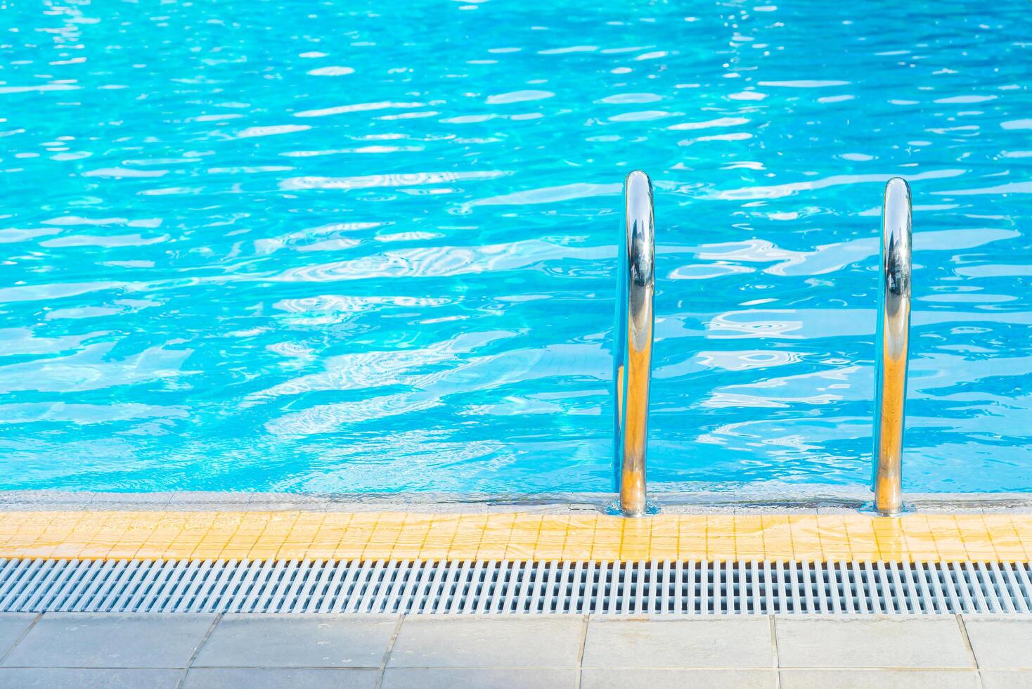 A pool with a ladder and a blue sky photo