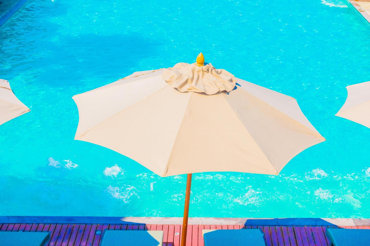 A pool with umbrellas and chairs photo