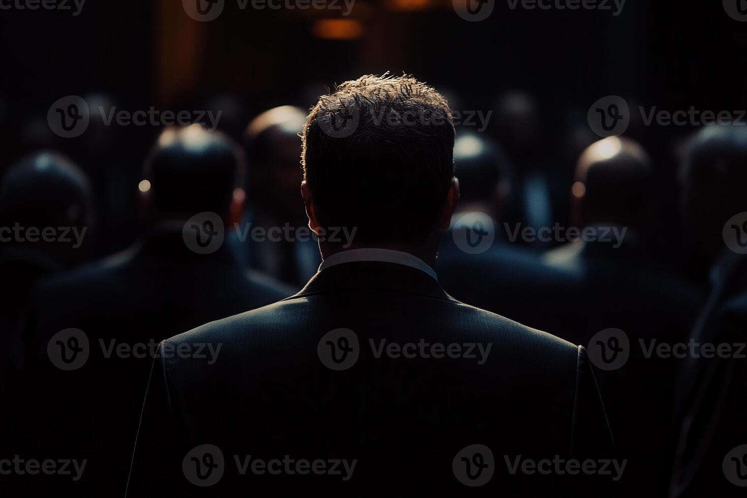 Businessman watching presentation with colleagues in dark conference room photo