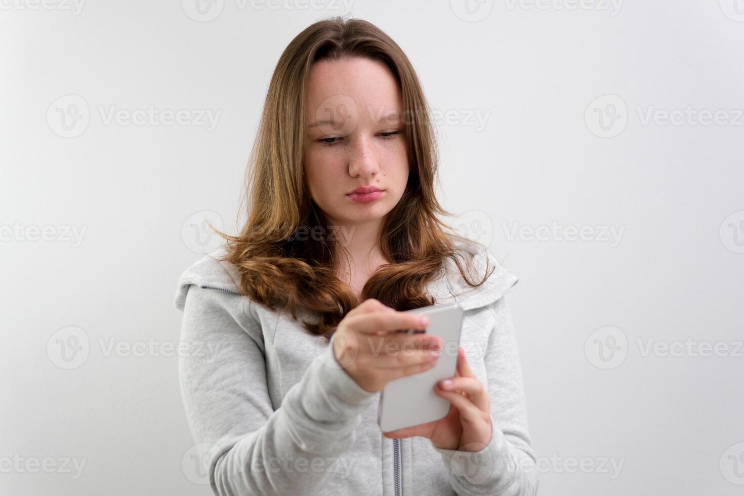 young teenage girl typing on laptop stand on white background hold gadget in hands search internet links learn online order online delivery photo