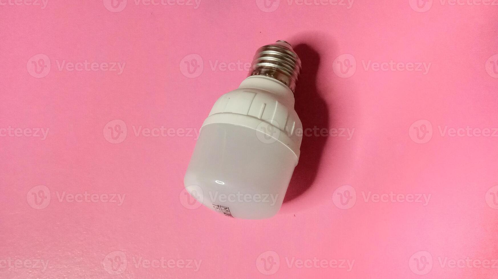 Energy efficient LED light bulb on a pink background. Concept of innovation, technology, and sustainability. photo