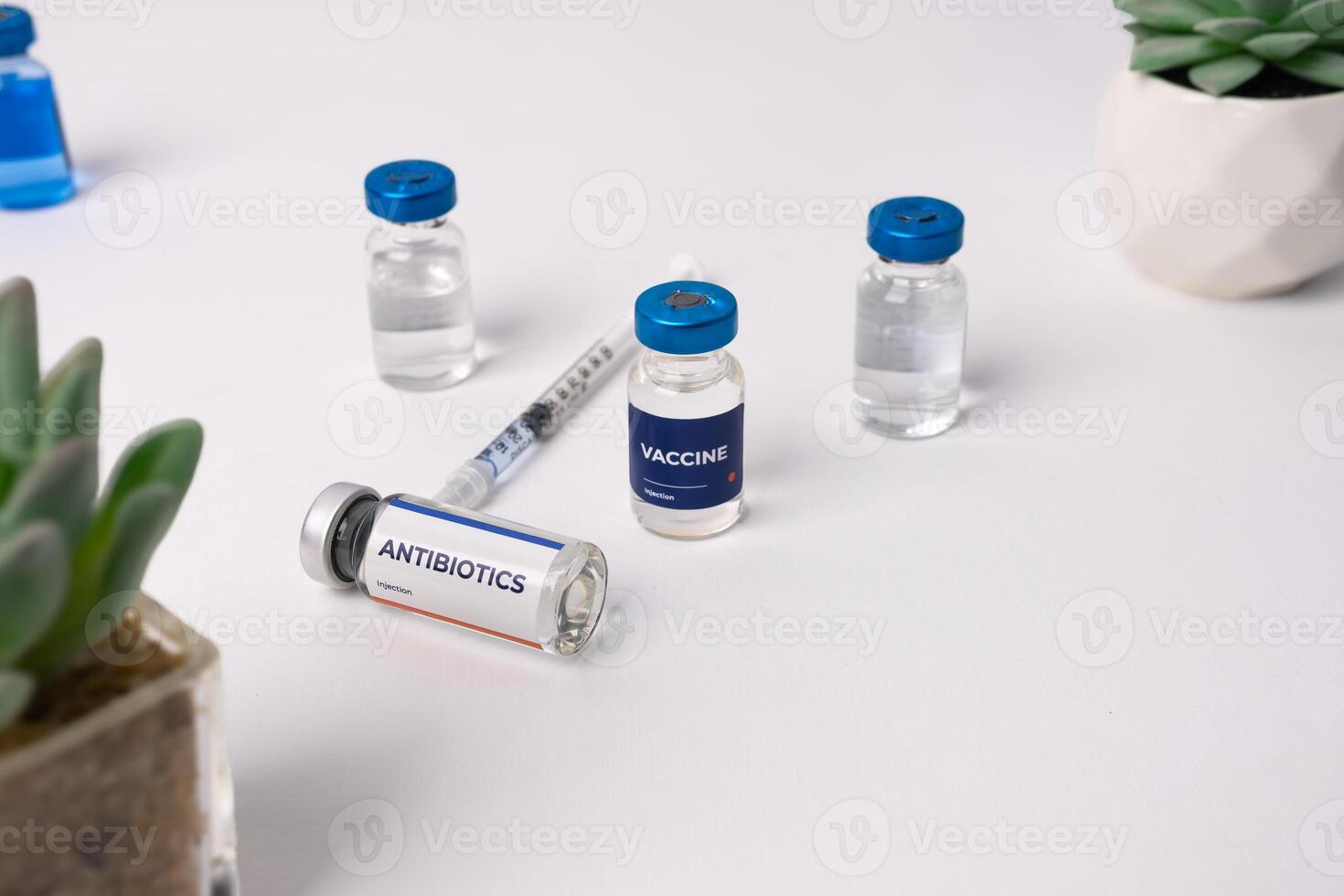 several vials and a syringe on a white table. health and medical concepts photo