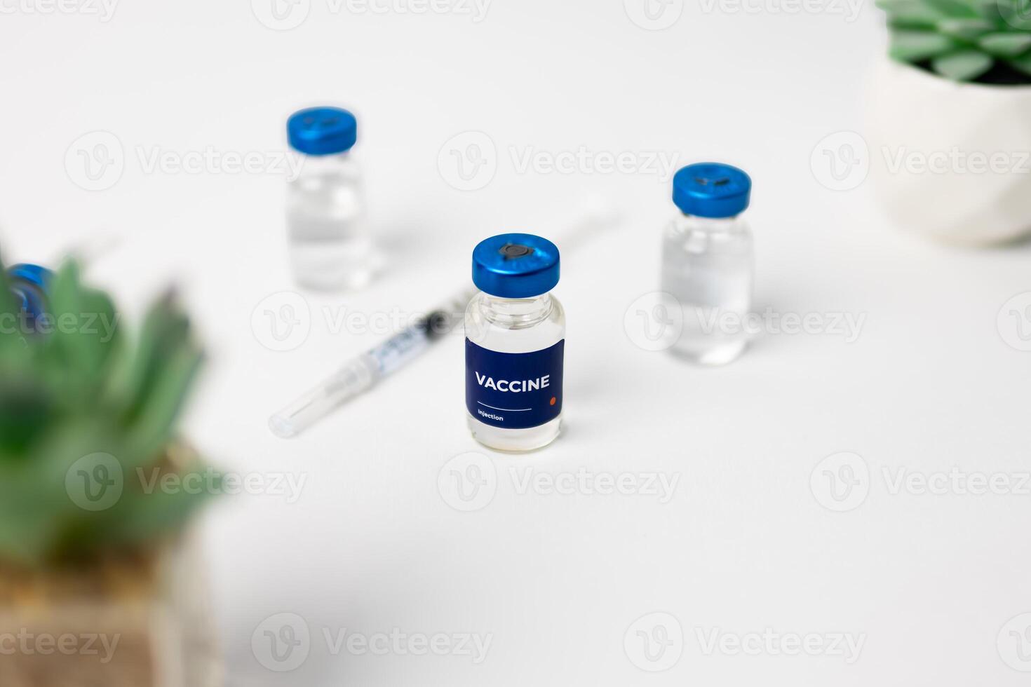 top view of 3 vaccines and a syringe on the table. health and medical concept photo