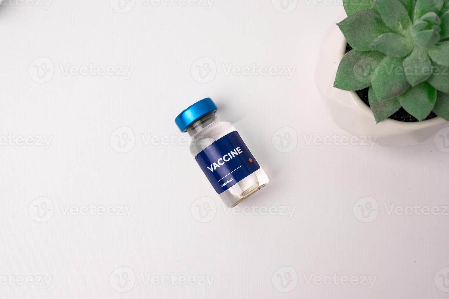 a vaccine lying on a white table with an ornamental plant in the corner. health and medical concepts photo