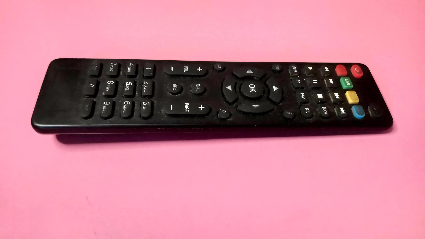 Generic Black TV Remote Control on Pink Background, Technology, Entertainment, Home Electronics photo