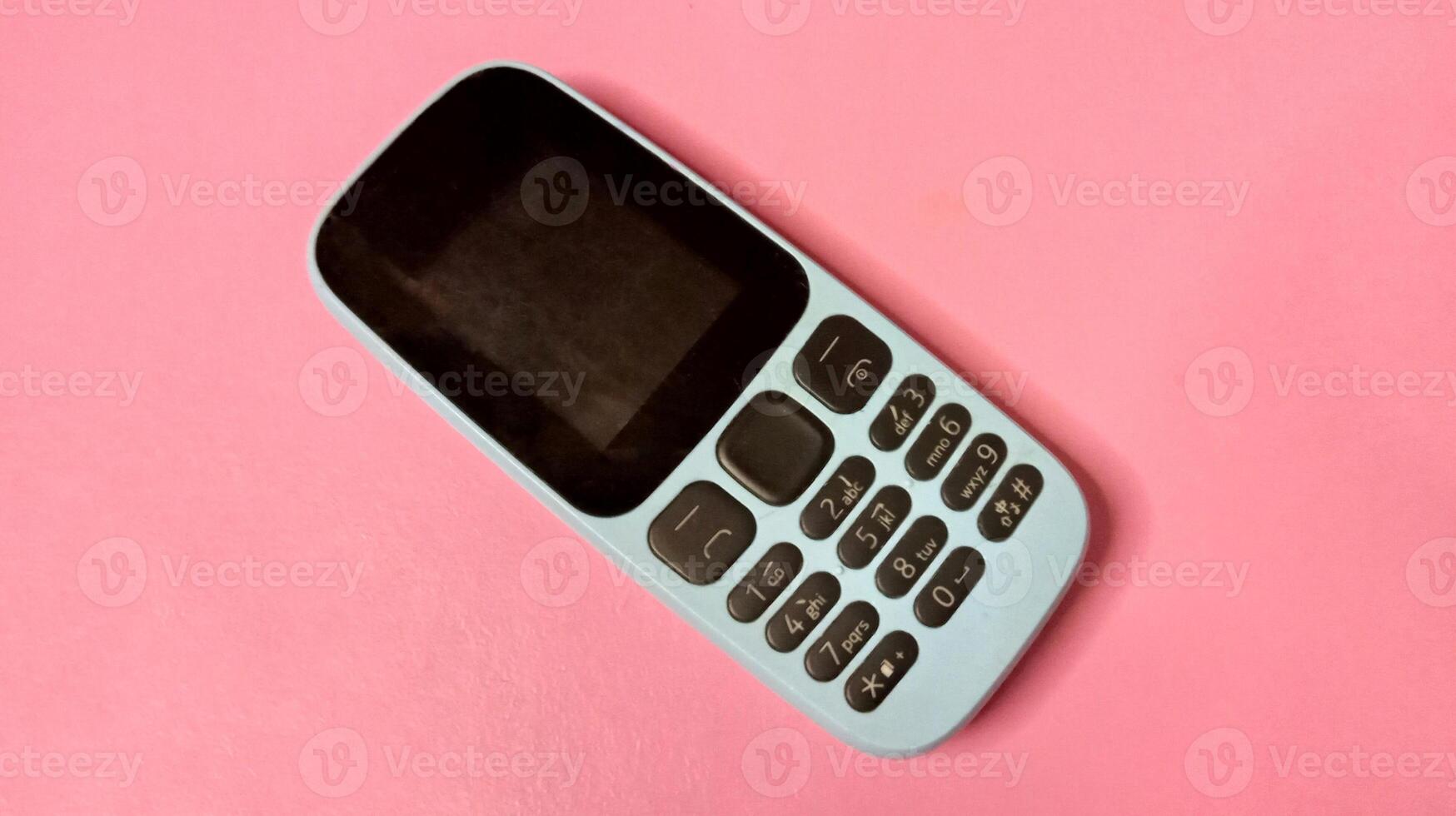 Basic Cell Phone on Pink Background, Minimalist Technology Image photo