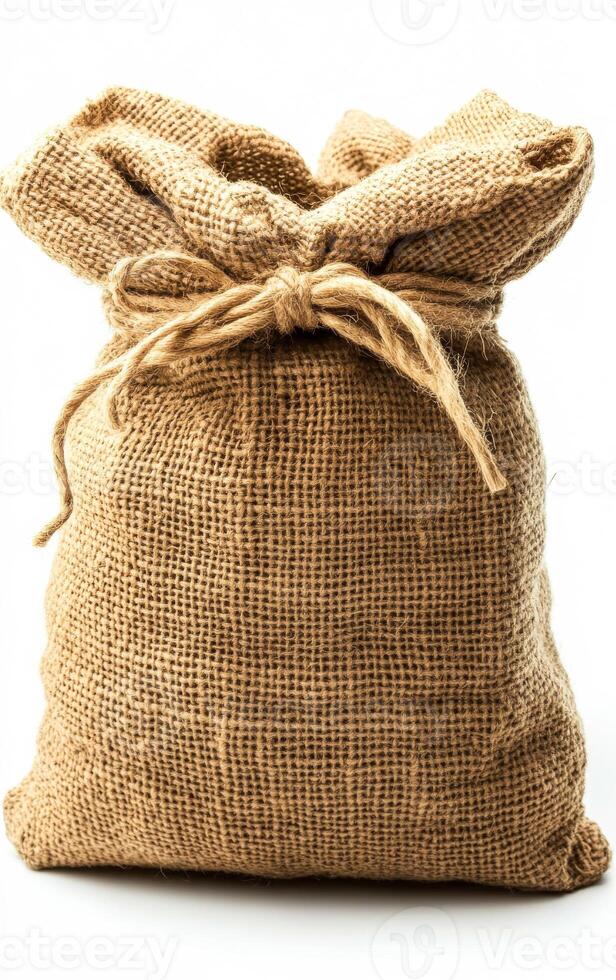 A brown bag with a white background. The bag is made of burlap and has a brown rope tied around it photo