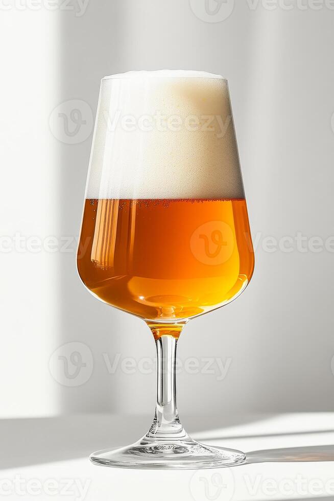 A glass of beer is sitting on a table. The glass is half full and the beer is foamy. Concept of relaxation and enjoyment, as the beer is a popular beverage for unwinding and socializing photo