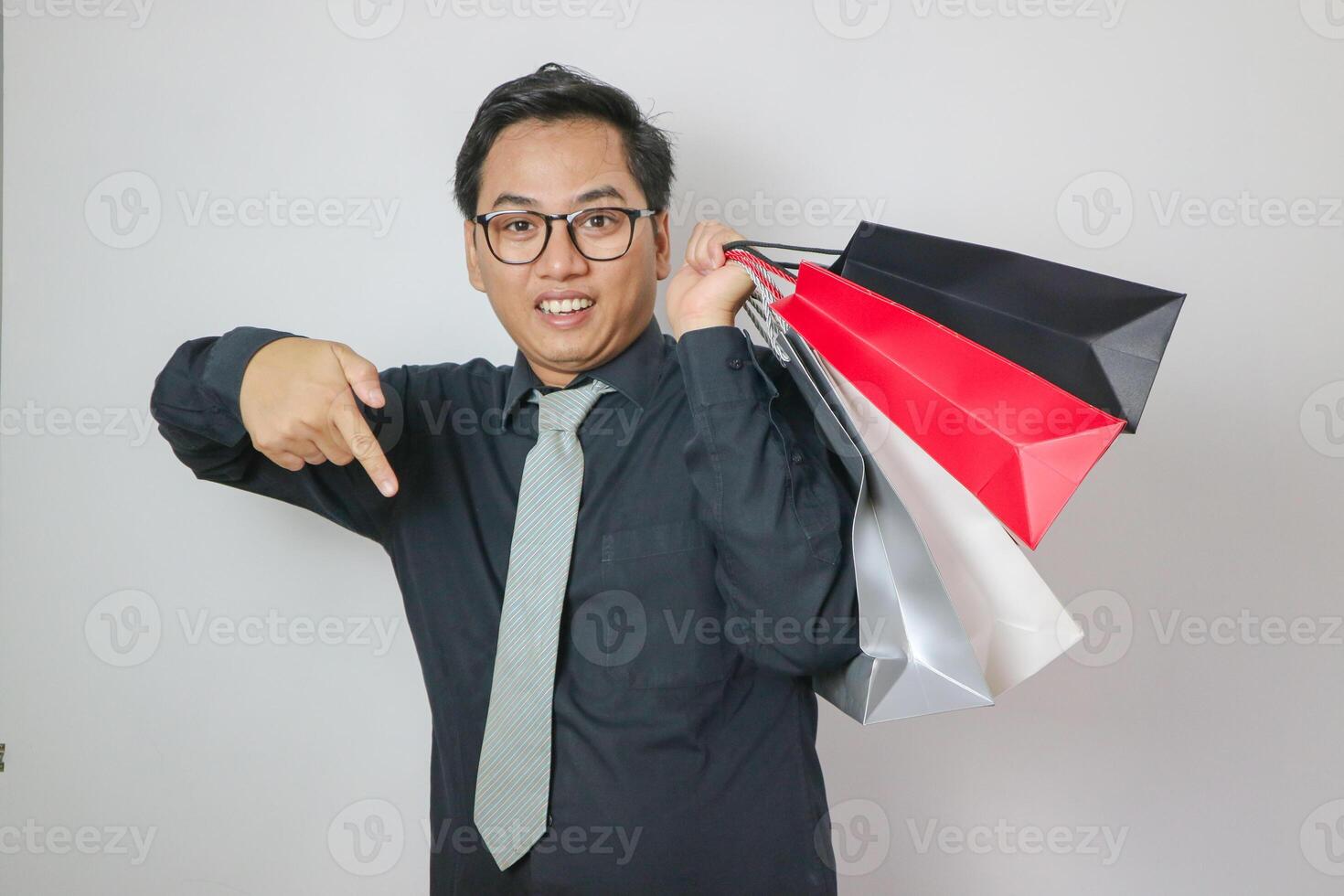 image of a handsome asian man holding a shopping bag in the hand posing on a white background. photo