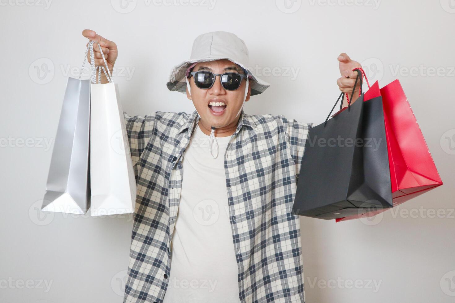 Asian man holding paper bag with fear and awe with mouth open for surprise, disbelief face photo