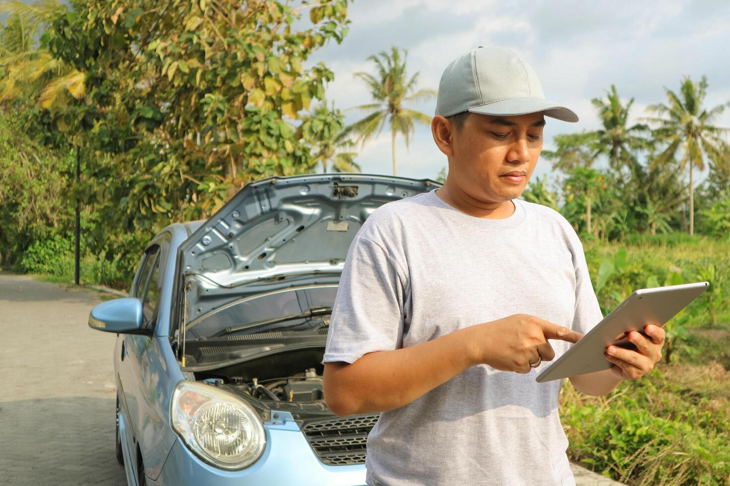 Professional car mechanic maintenance vehicle. The mechanic opens the front of the car. Checking the broken engine. Check the damage as listed. Repair car outside service. photo