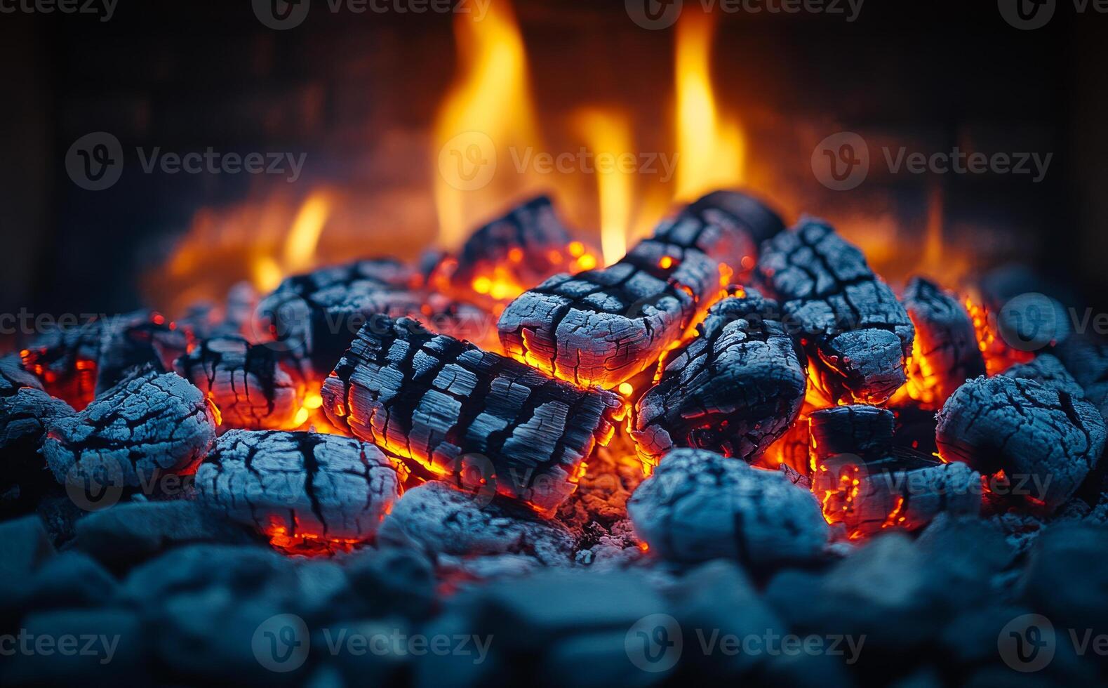 Burning charcoal and glowing embers in a fireplace. Charcoal lays in a fireplace, glowing with bright orange embers, illuminating the cozy warmth of the fire. photo
