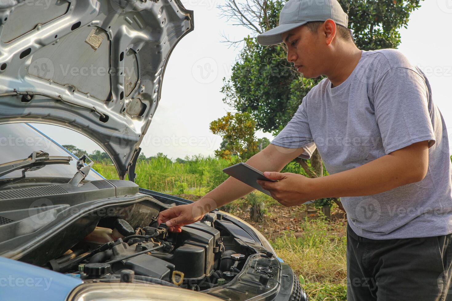 Auto check up and car service shop concept. Mechanic writing job checklist to clipboard to estimate repair quotation to client at workshop garage. photo