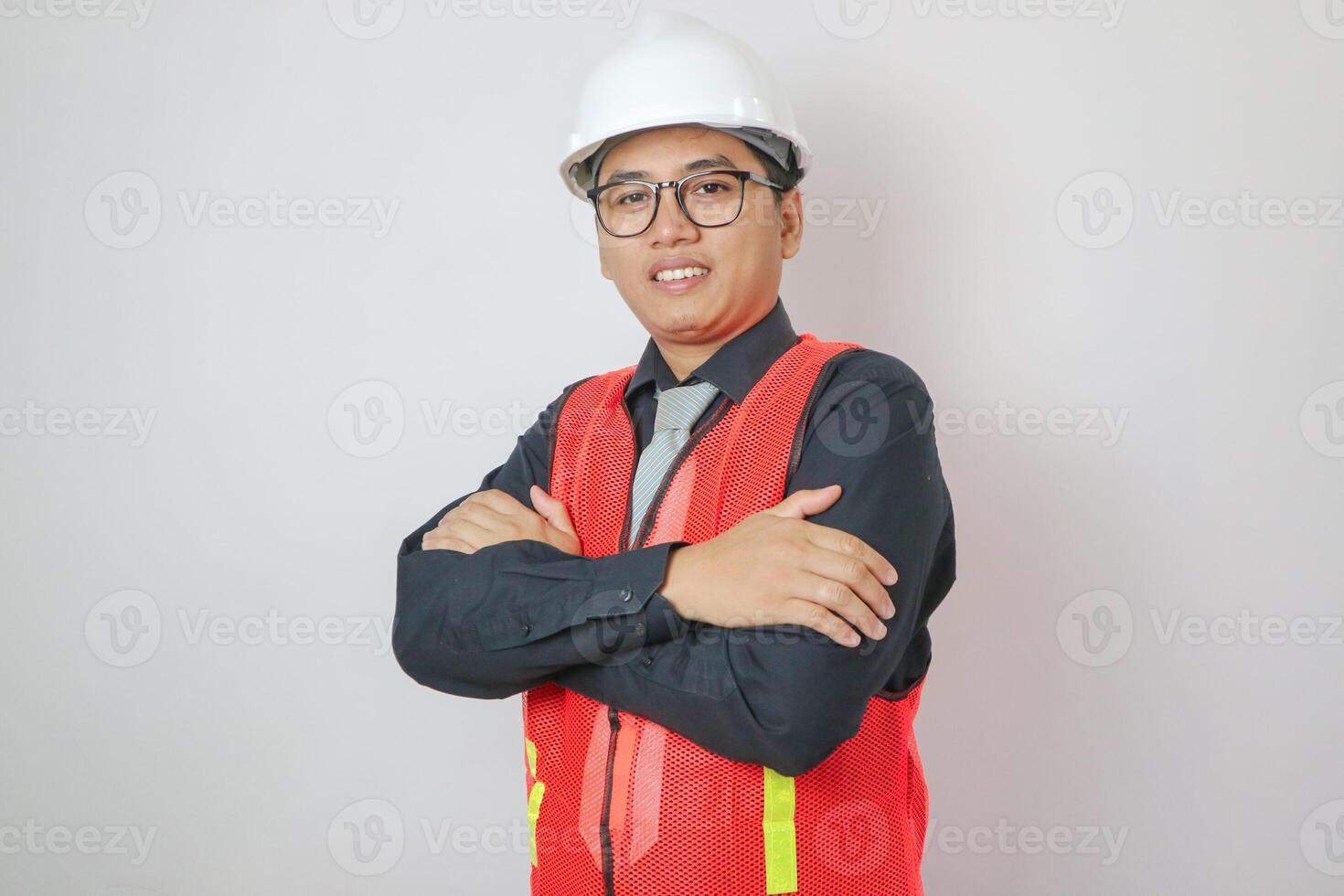 A handsome male engineer or architect with a white helmet on a white background standing in a photo studio. happy smiling worker
