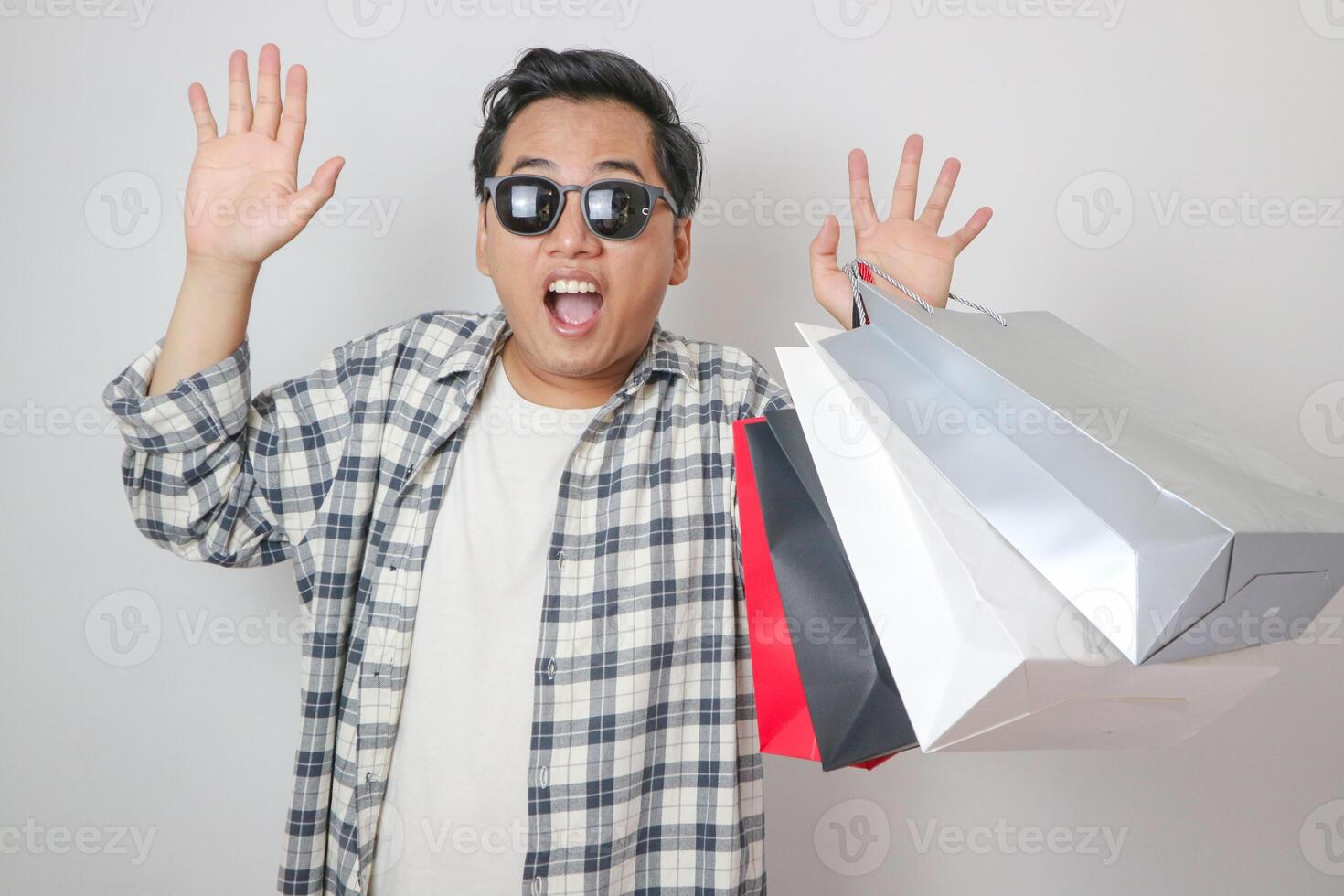 Funny surprised and shocked face of Asian man see product in the shopping bag photo