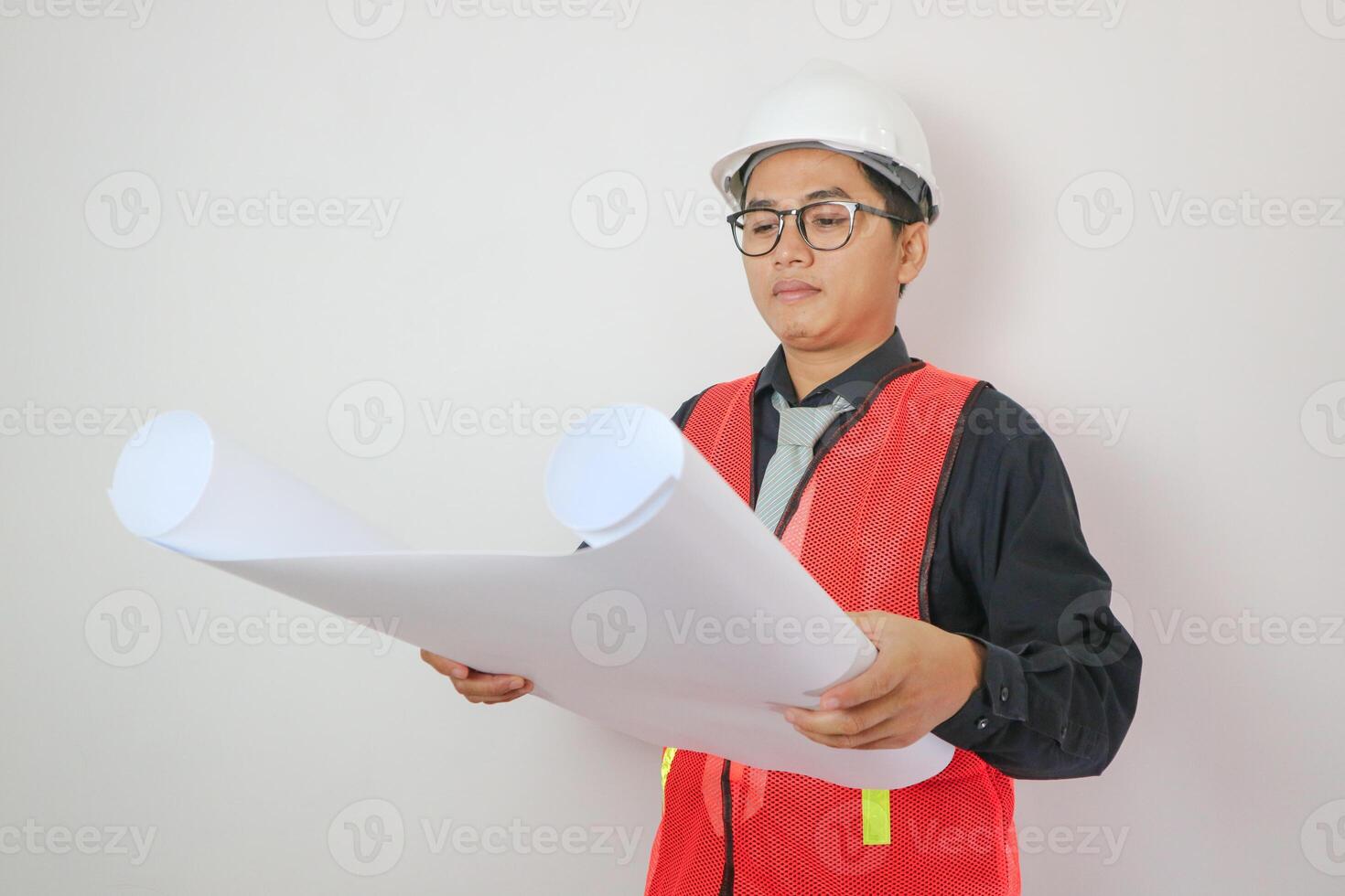 Young handsome asian man in casual dress with white hardhat hand holding paperwork blueprint in architect and engineer worker isolated in white background in studio photo