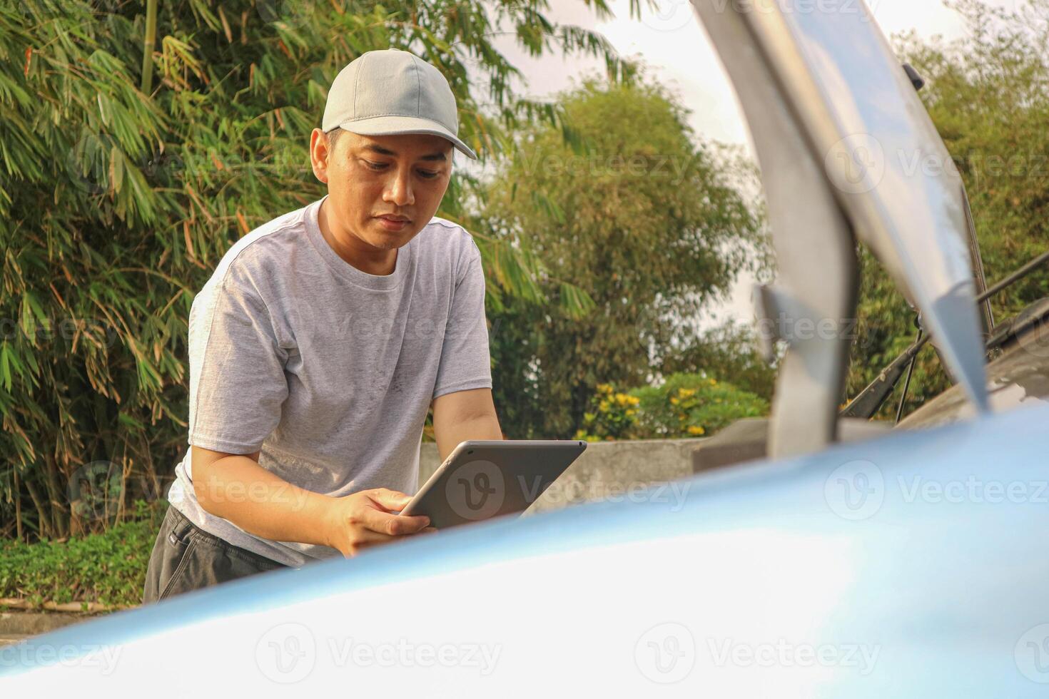 Asian men maintenance checking car service via insurance system at garage with using tablet photo