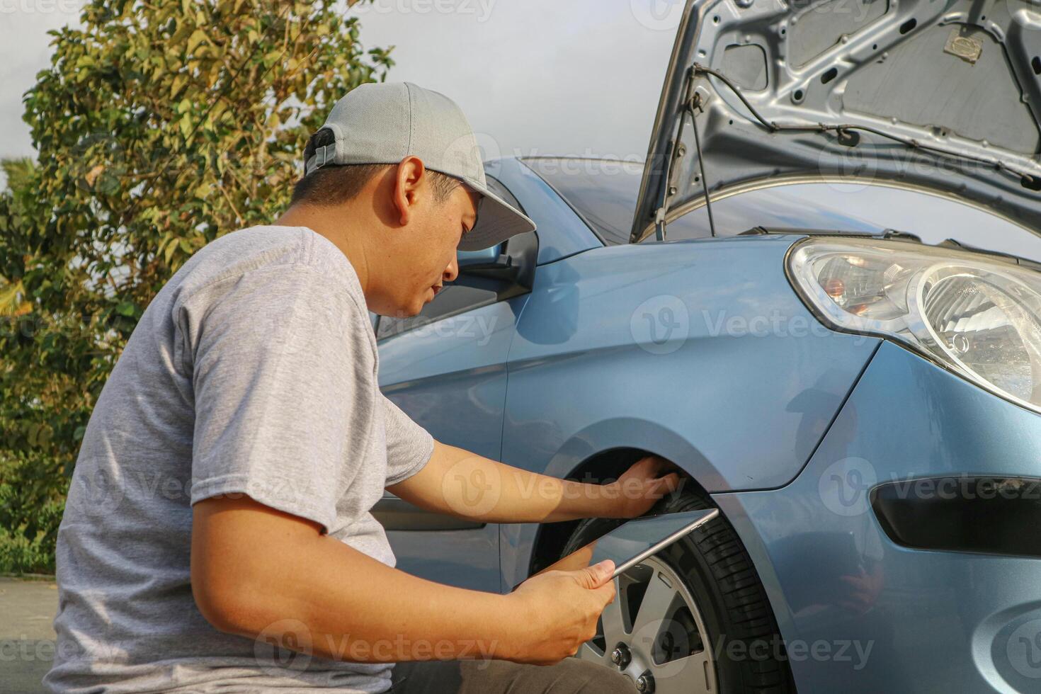 Close up auto mechanic man checking car tire . Car service. Hands replace tires on wheels. Tire installation concept. photo