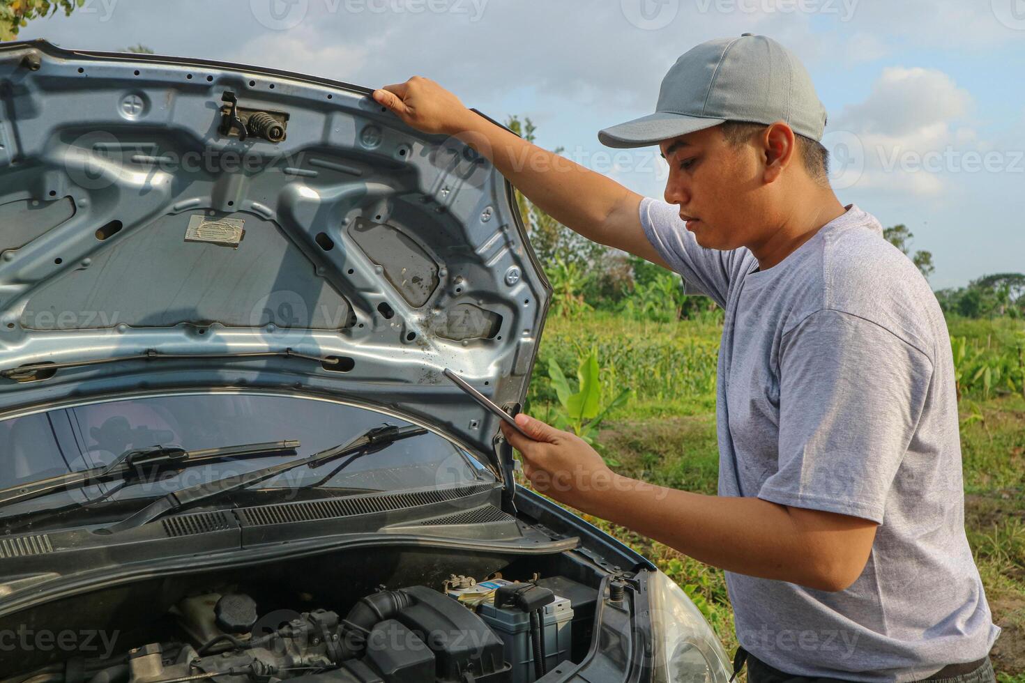 Asian men maintenance checking car service via insurance system at garage with using tablet photo
