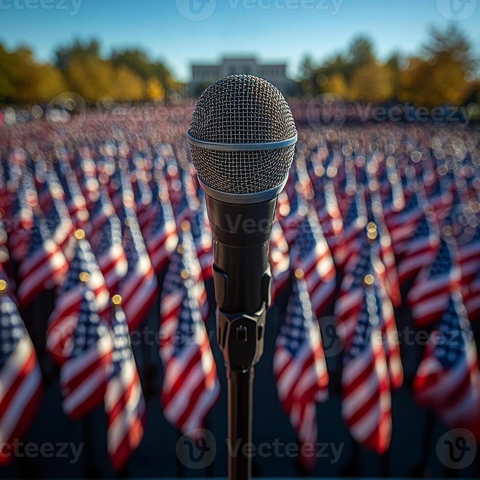 A microphone is pointed at a large crowd of American flags. The microphone is black and silver. The flags are red, white, and blue photo