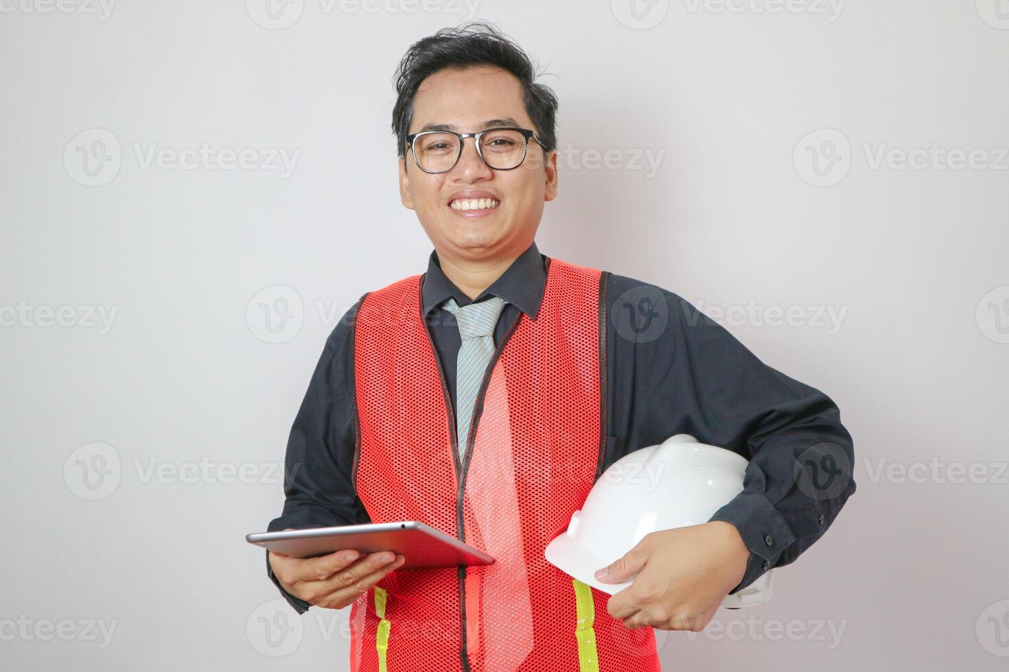The Asian engineer was holding tablet screen and helmet safety. photo