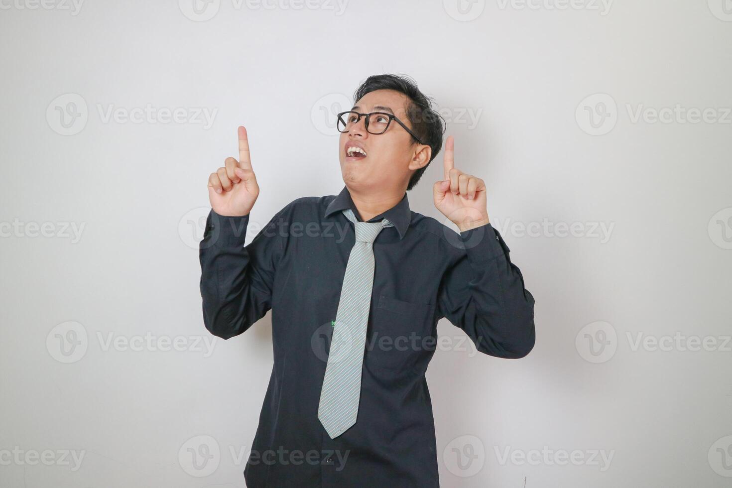 young asian men wearing black shirt pointing up copy space photo