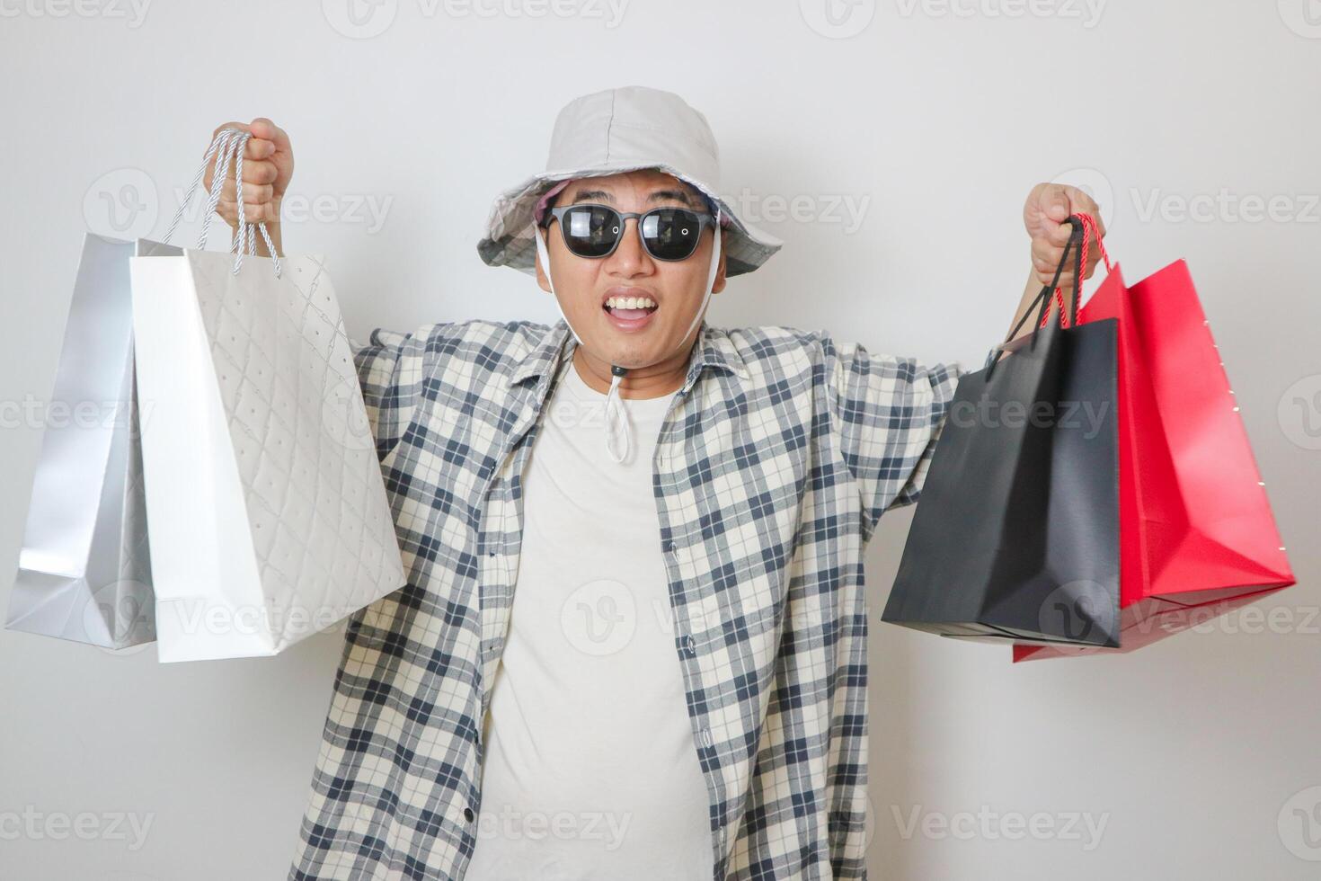 portrait of happy smiling handsome Asian man carrying shopping bags. Online shop concept. photo
