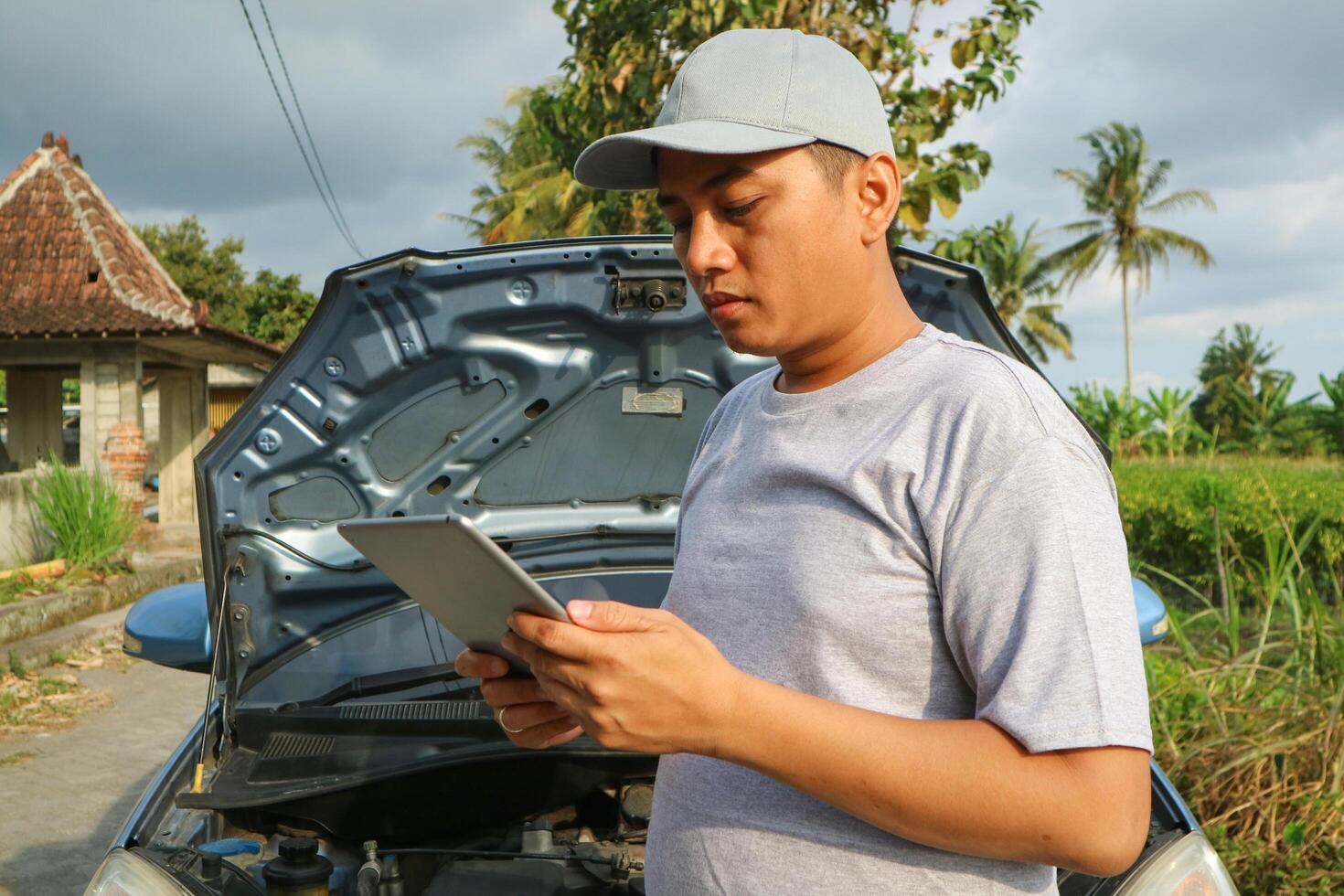 Asian men maintenance checking car service via insurance system at garage with using tablet photo