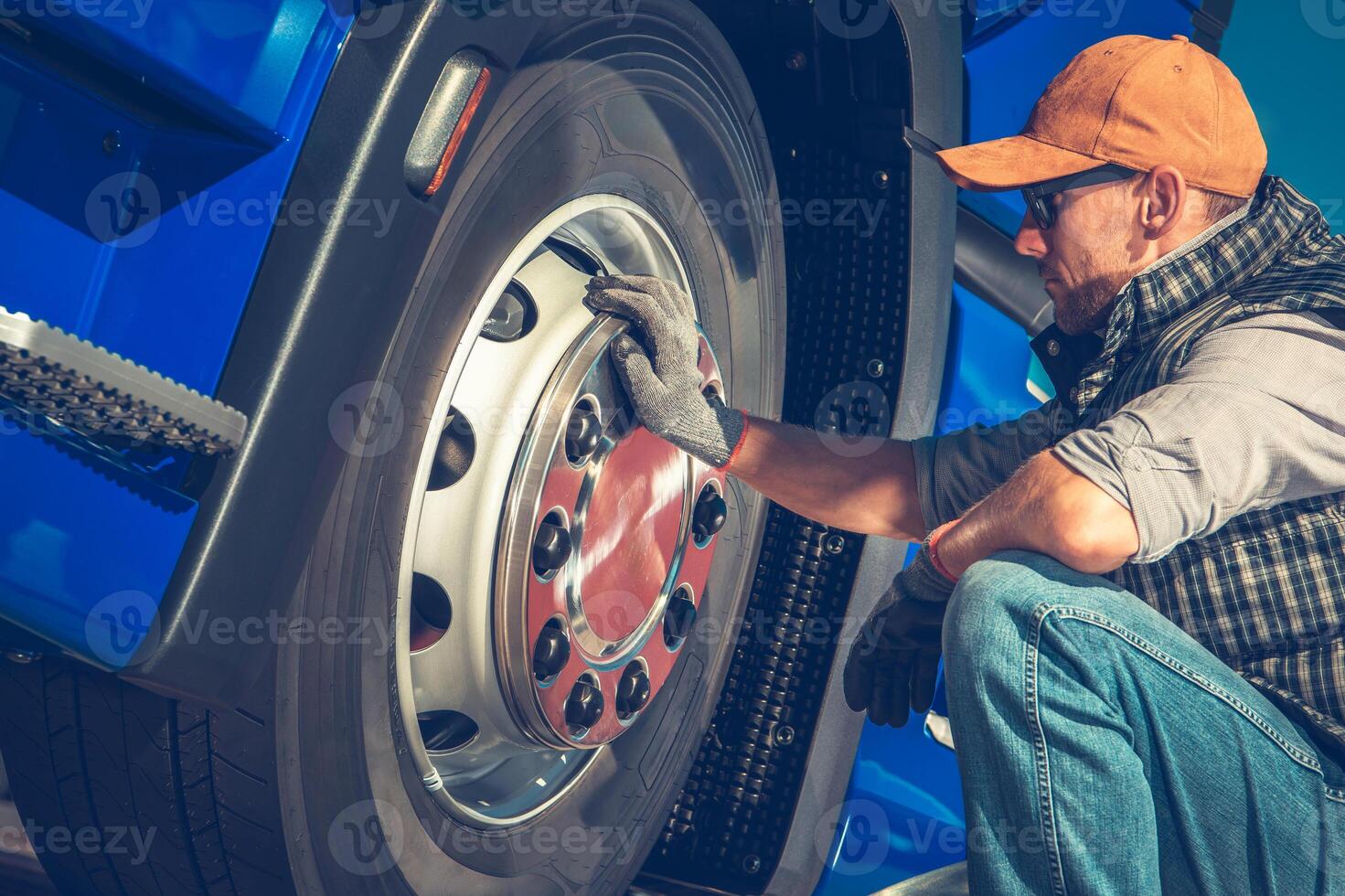 Mechanic Inspecting Semi Truck Tire in Bright Workshop During Afternoon photo