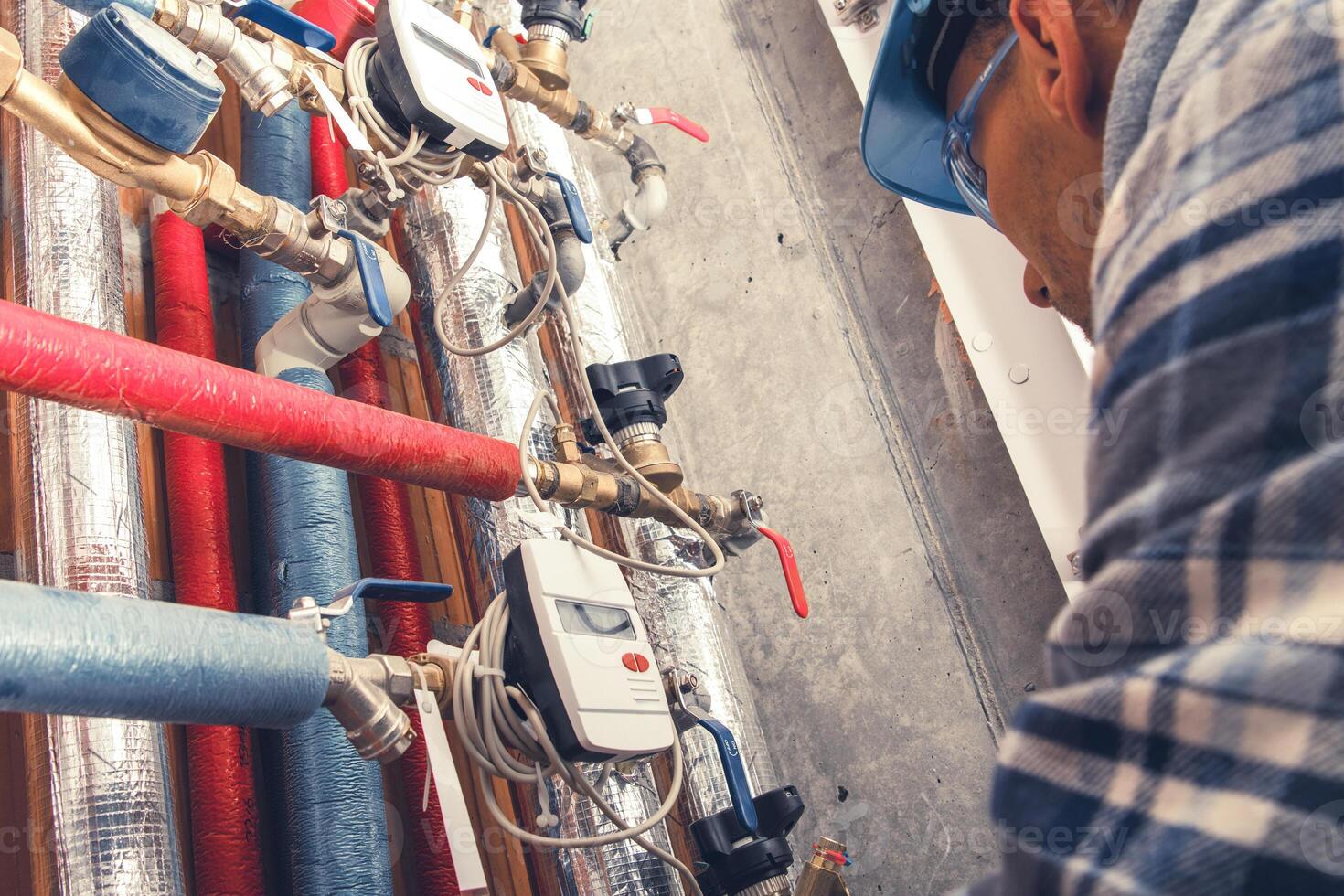 Skilled Worker Examining Plumbing System in Industrial Facility During Daytime photo