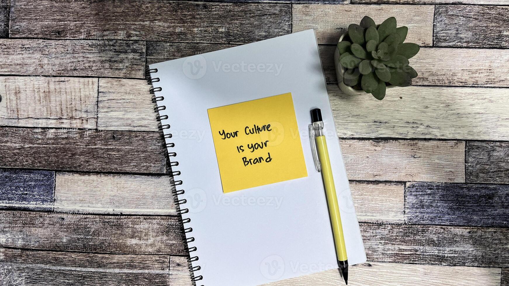 Concept of Your Culture is your brand write on sticky notes isolated on Wooden Table. photo