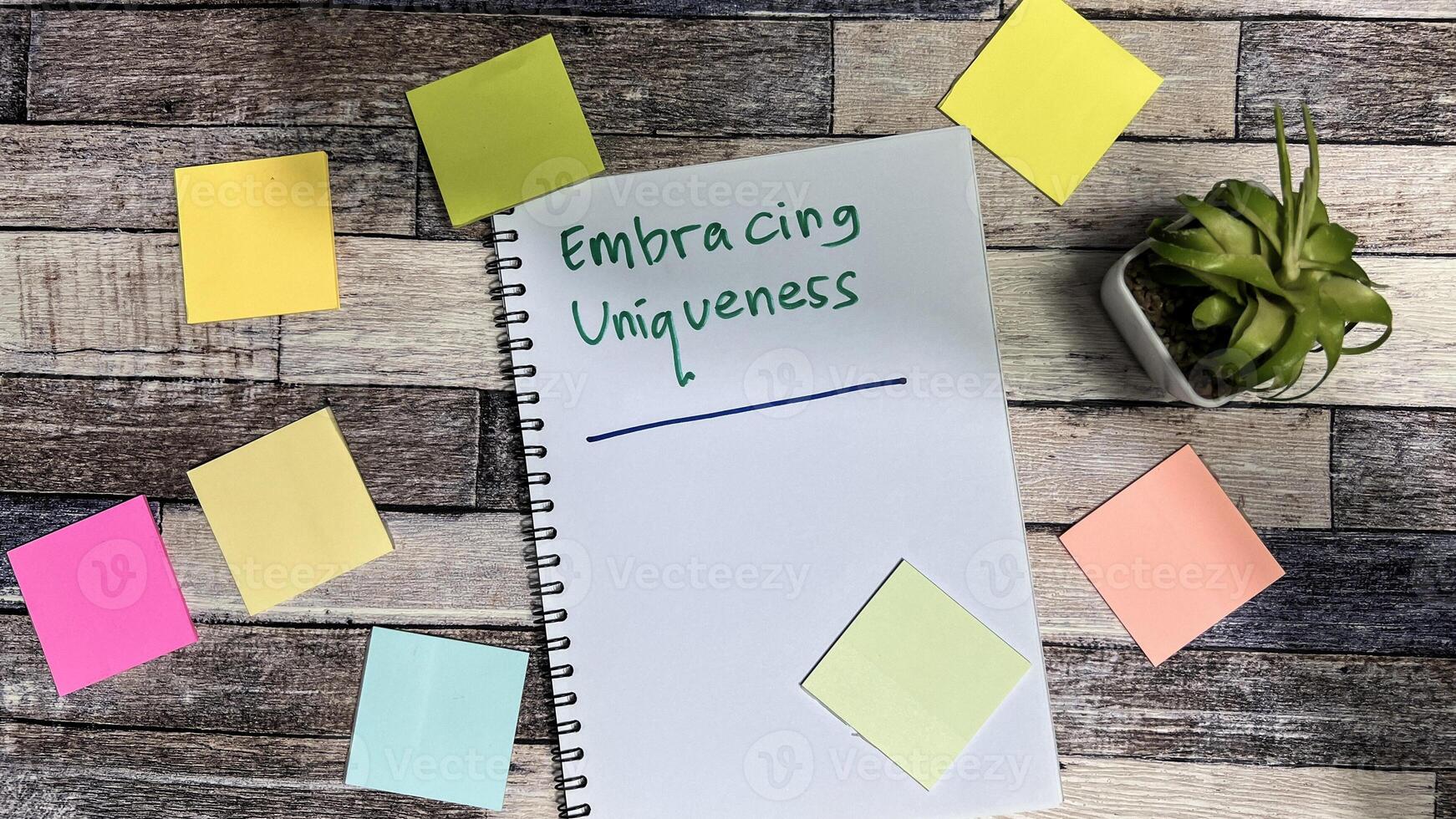 Concept of Embracing Uniqueness write on book isolated on Wooden Table. photo