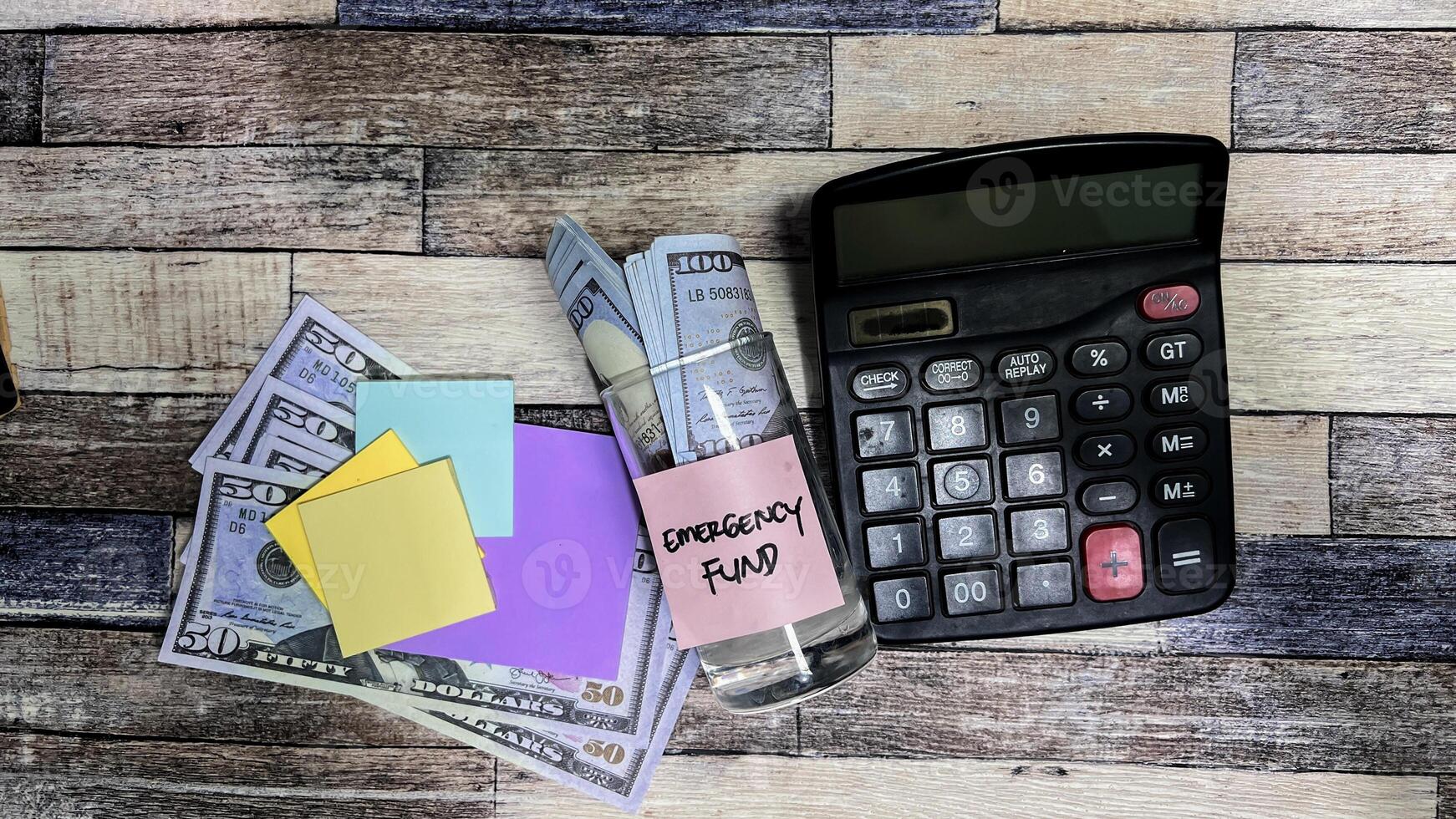 Concept of Emergency Fund write on sticky notes on a glass isolated on Wooden Table. photo