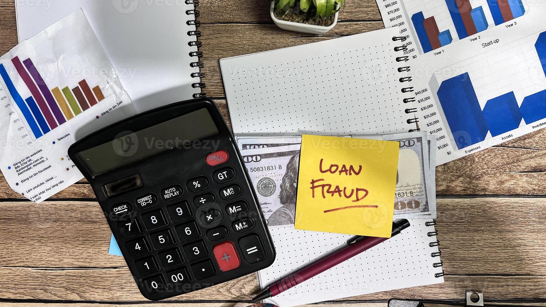 Concept of Loan Fraud write on sticky notes isolated on Wooden Table. photo