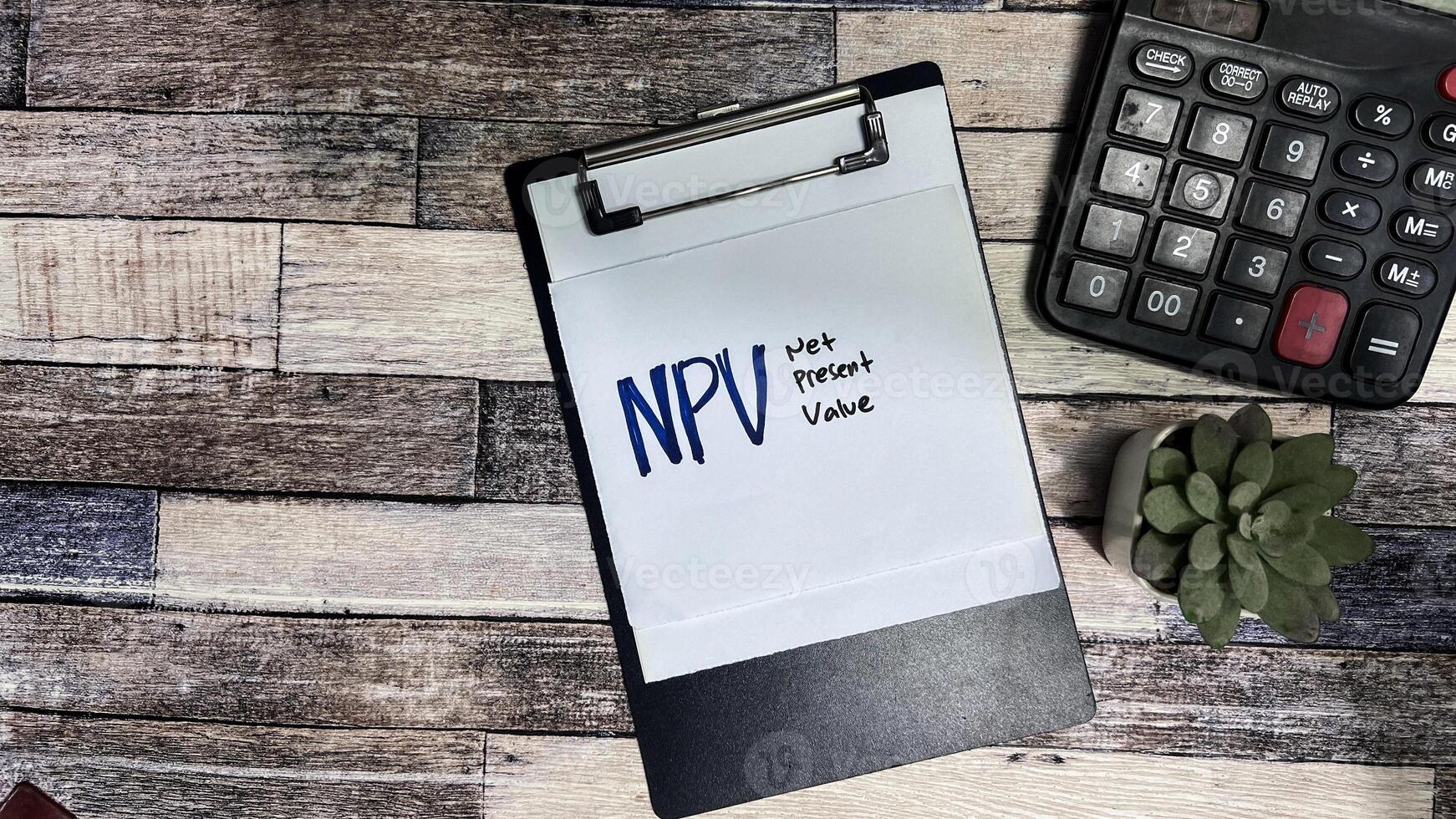 Concept of NPV - Net Present Value write on sticky notes isolated on Wooden Table. photo