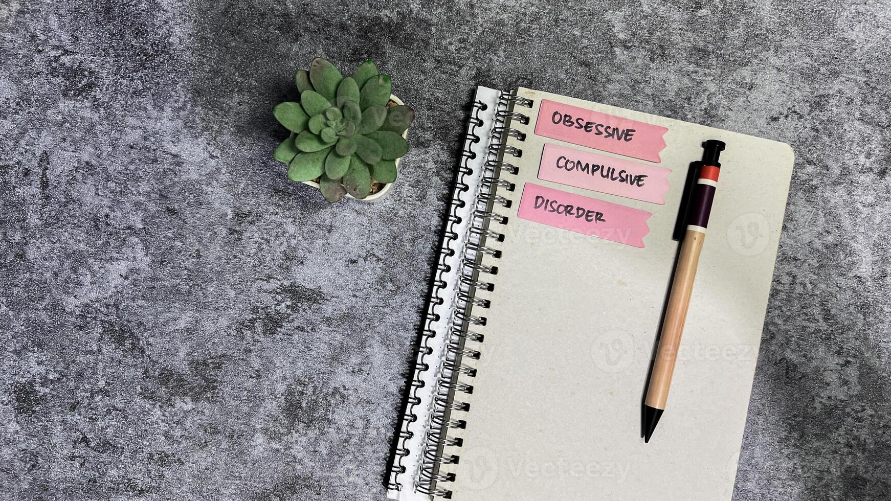 Concept of Obsessive Compulsive write on sticky notes isolated on Wooden Table. photo