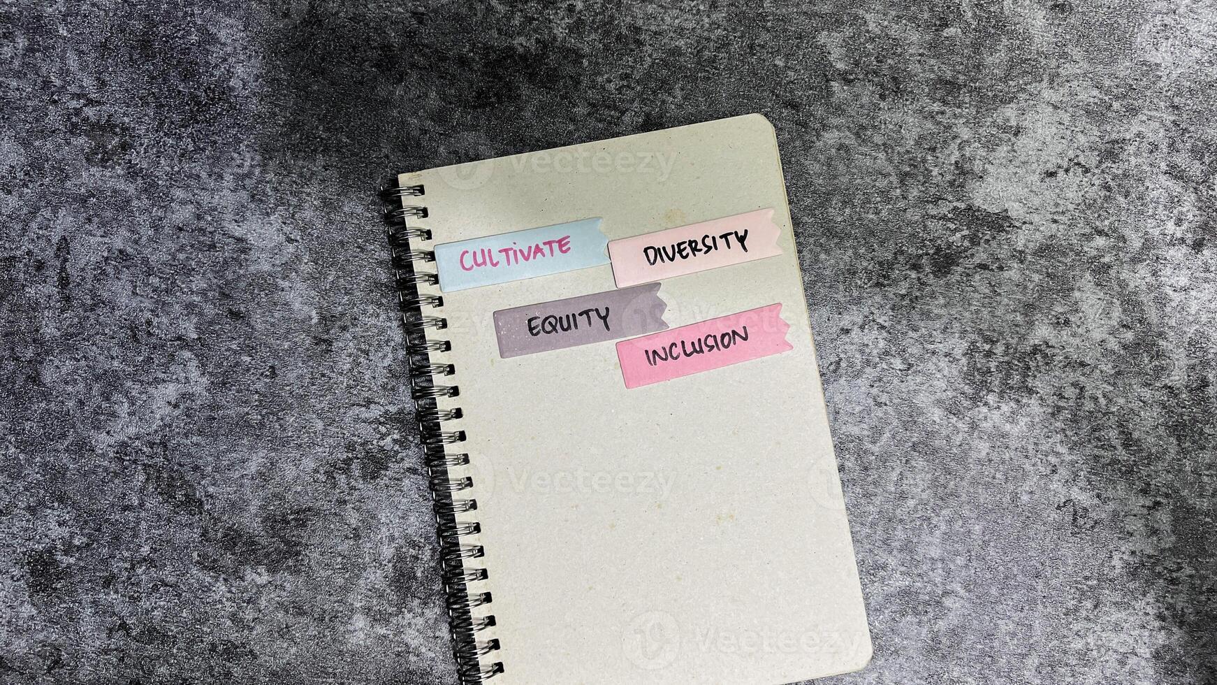 Concept of Cultivate, Diversity, Inclusion, and Equity write on sticky notes isolated on Wooden Table. photo