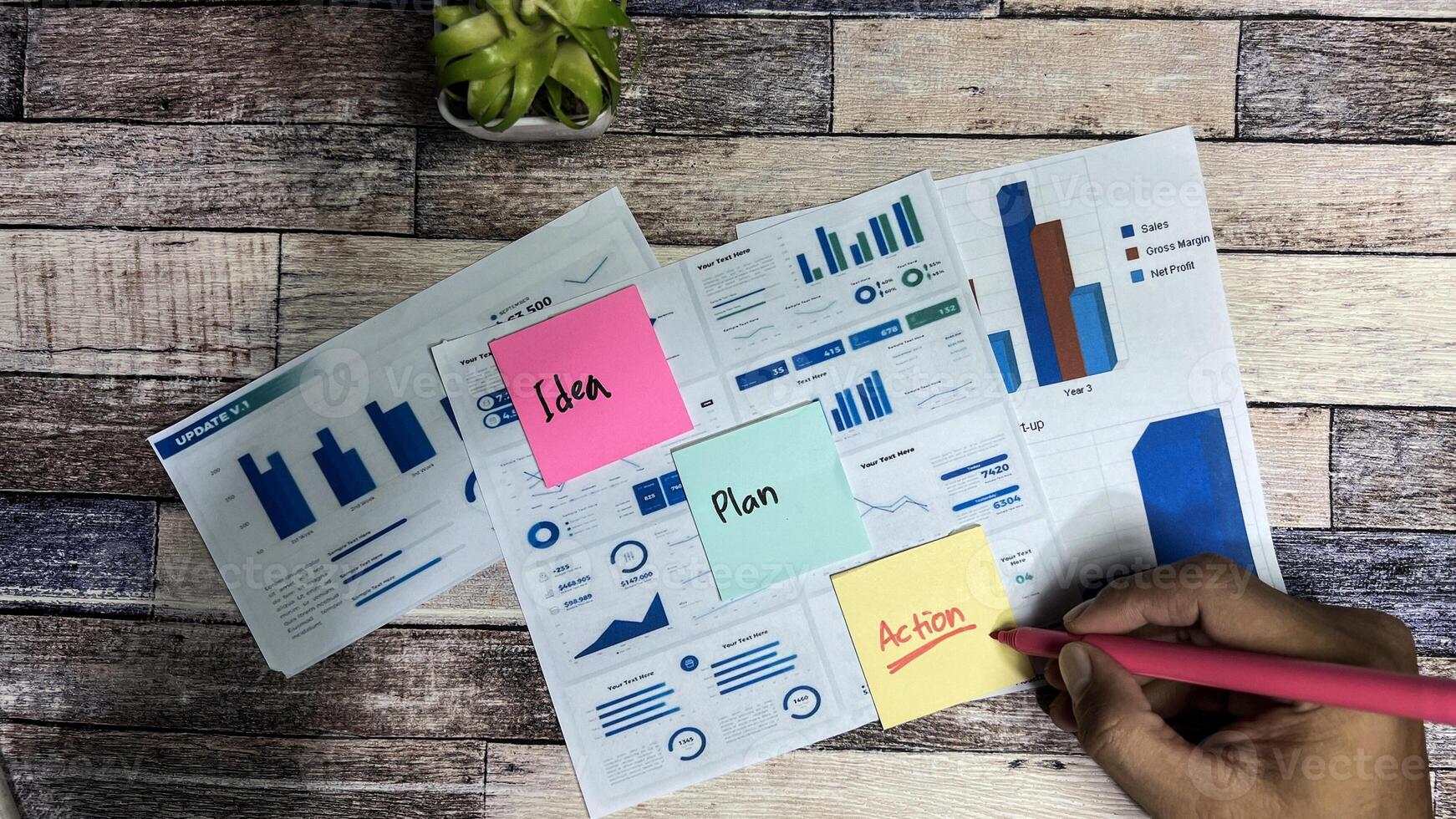 Concept of Idea, Plan, Action write on sticky notes isolated on Wooden Table. photo