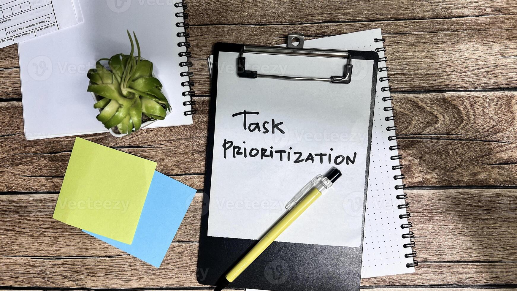 Concept of Task Prioritization write on paperwork isolated on Wooden Table. photo