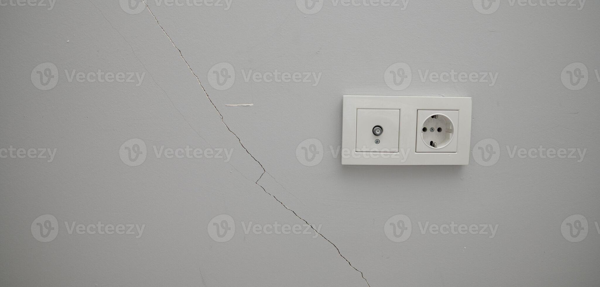 A white wall with a white outlet and a white light switch photo
