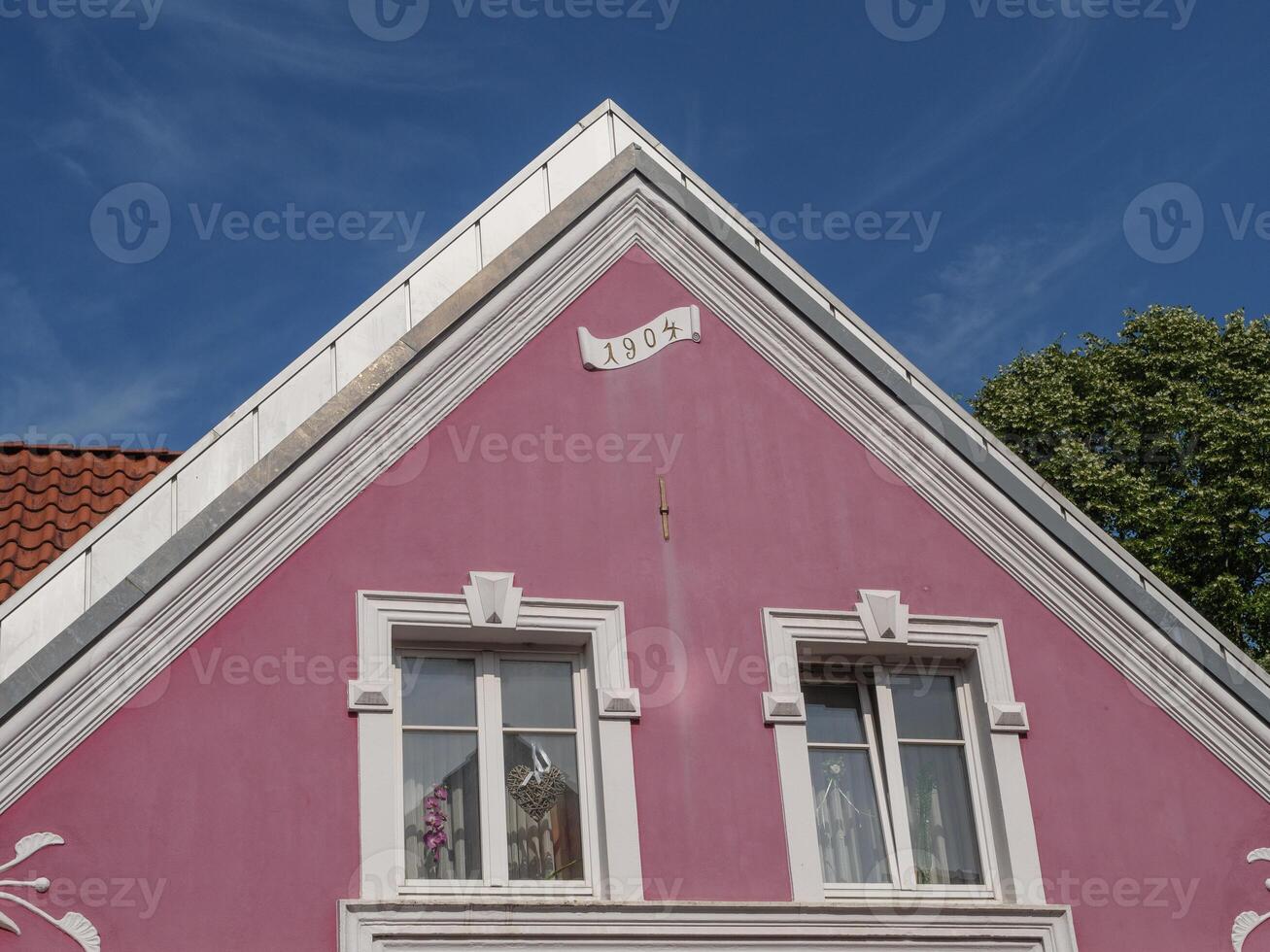 A pink house with a clock on it photo