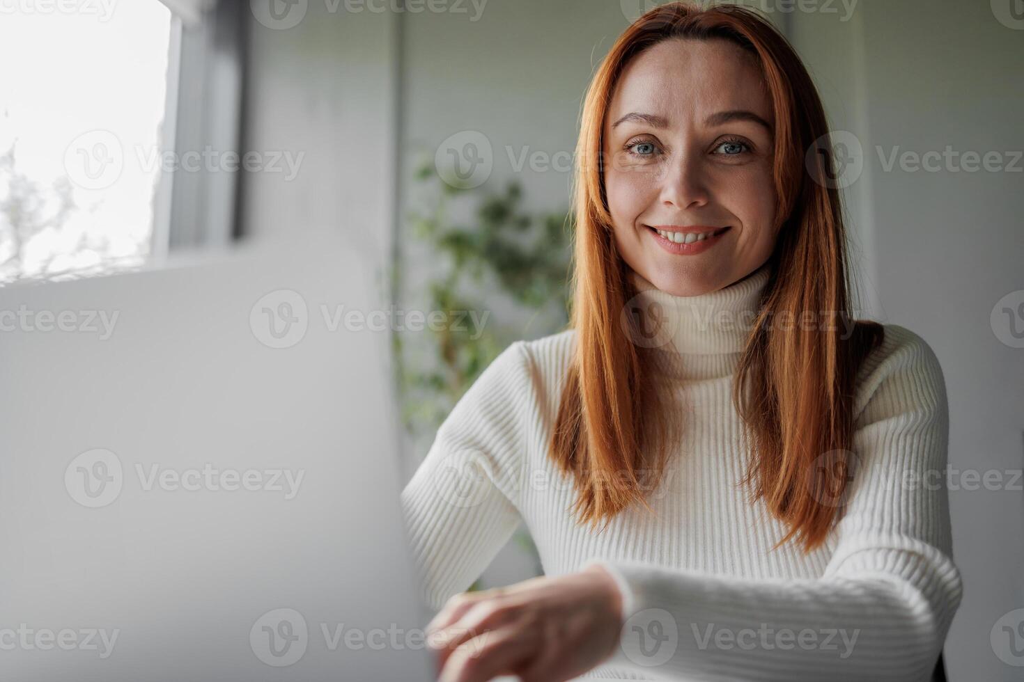 Close-up portrait of a business woman working remotely or in the office. 30s 40s business lady in front of a computer managing her business. photo