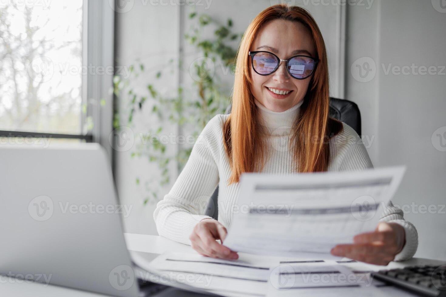 Happy mature woman with documents or invoices. Business lady being happy about her business. Accountant consulting some documents. photo