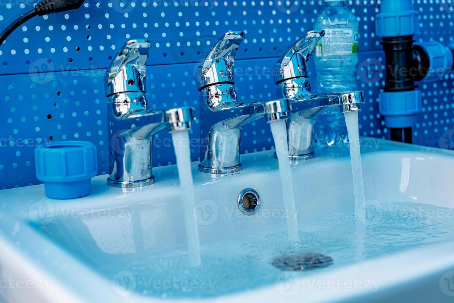 Triple Cascade A Dance of Water in a Gleaming Sink - Liquid Threads Weaving Through Chrome Faucets photo